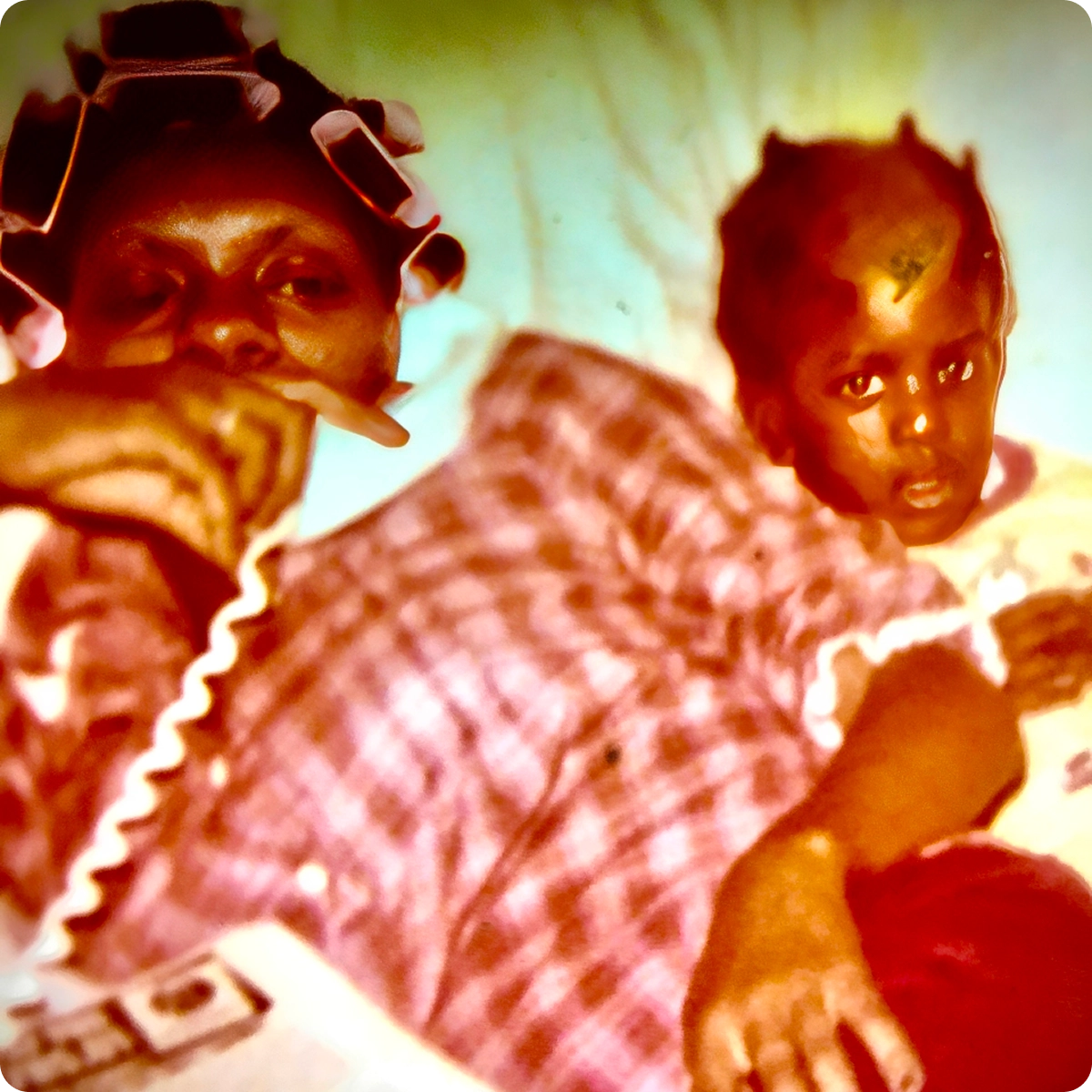Woman and child resting on bed together.