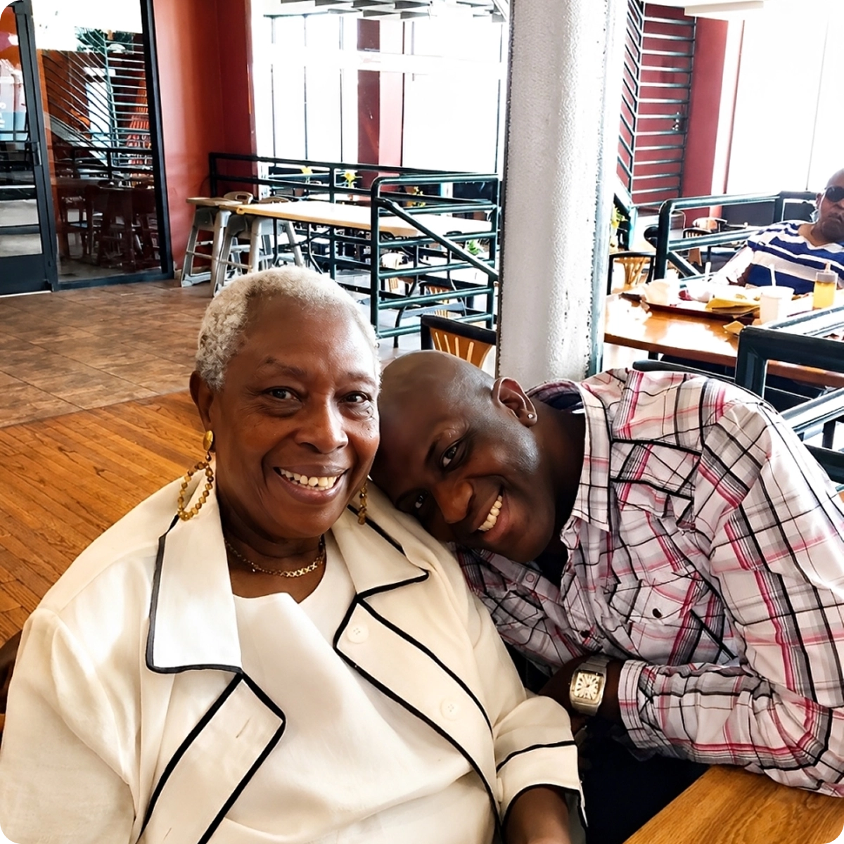 Smiling individuals sitting together at restaurant.